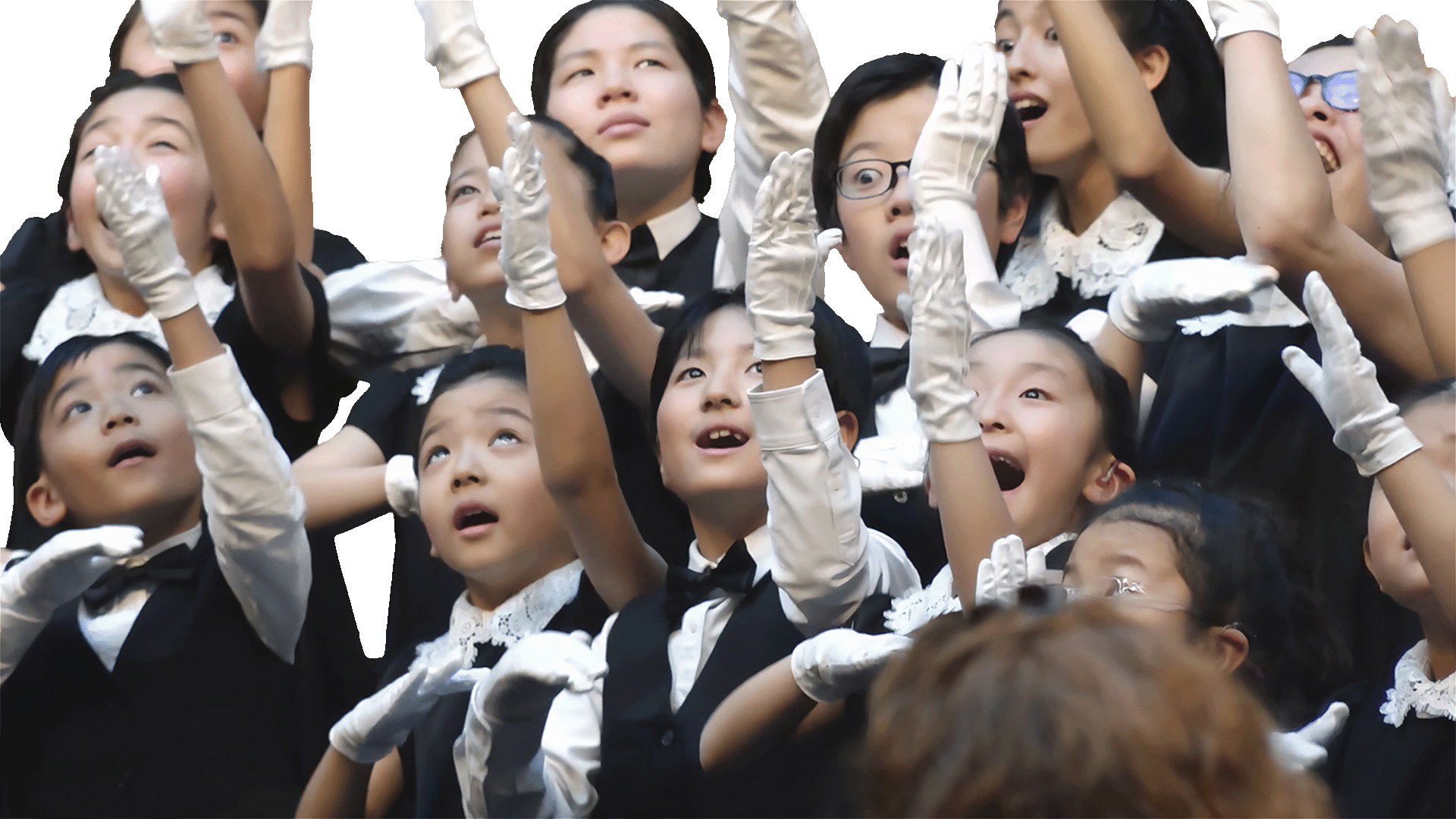 白い手袋をつけて手話で歌う子どもたち